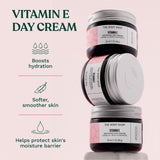 Three jars of The Body Shop Vitamin E Day Cream on a light pink background with text about product benefits. Boosts hydration. Softer, smoother skin. Helps protect skin's moisture barrier.